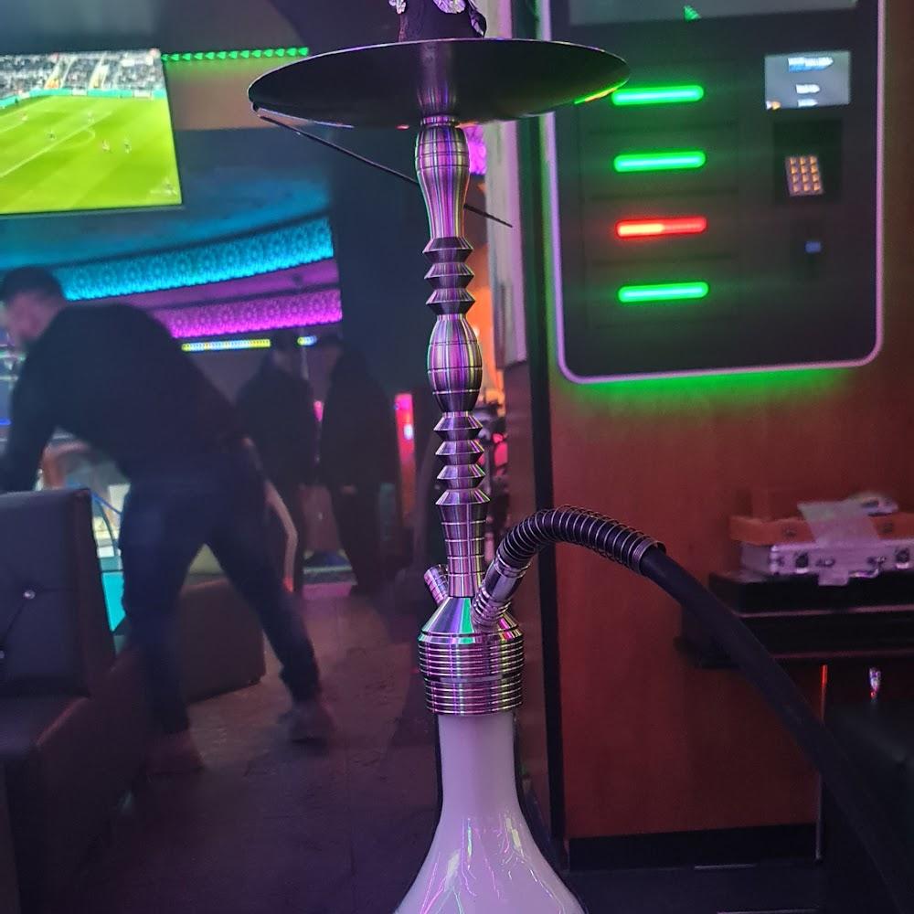 A silver hookah in a dimly lit room.